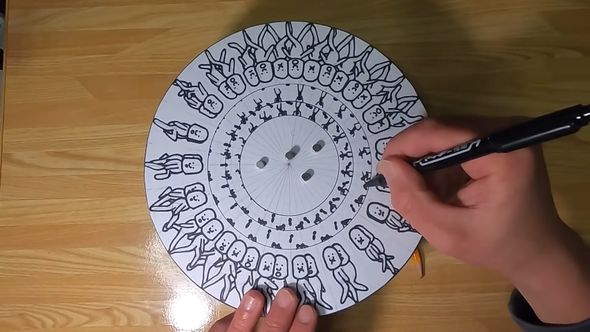 円盤に描かれたよじ上る人と降りてくる人