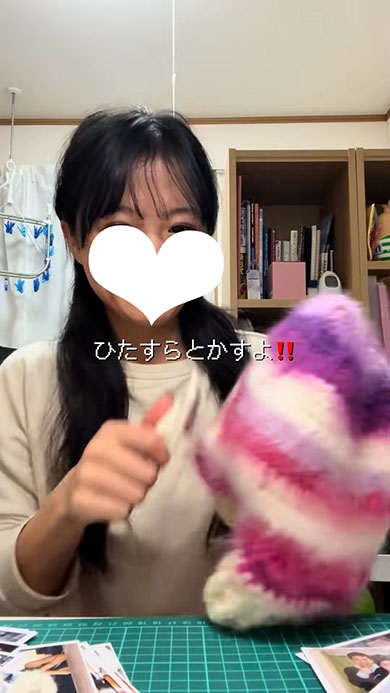 ニットの帽子を犬用ブラシでとかす女性