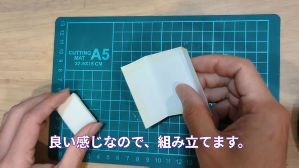 段ボール製の中身を包むように縮小印刷したパッケージを貼り合わせる