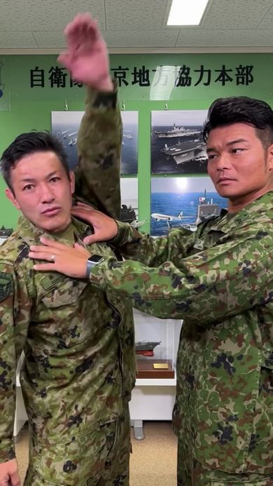 腕を大きく動かして相手の拘束を解く方法を実演する男性自衛官