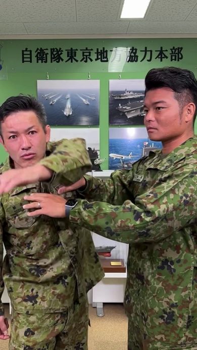 上げた左腕を体の右側へ倒して拘束を解く男性自衛官