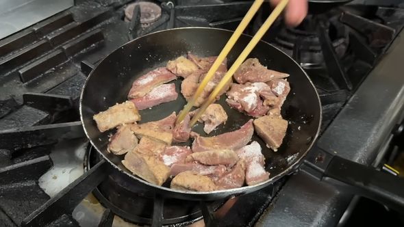 味付けして片栗粉をまぶした豚レバーを炒める