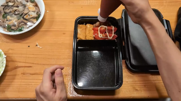 おかずを詰める兄