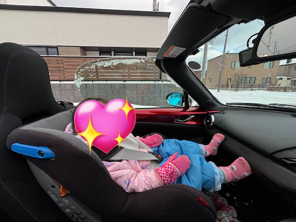 積雪の中オープンカー状態で運転するマツダロードスター