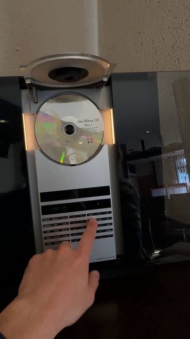 バング＆オルフセンのCDプレーヤーのボタンを押してトレイを閉じさせる