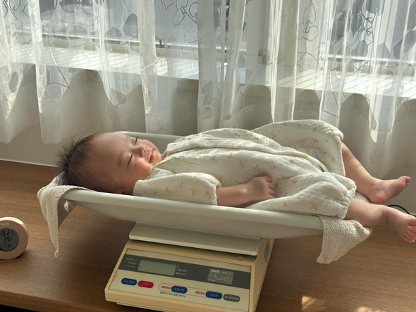 体重計の上で眠る赤ちゃん