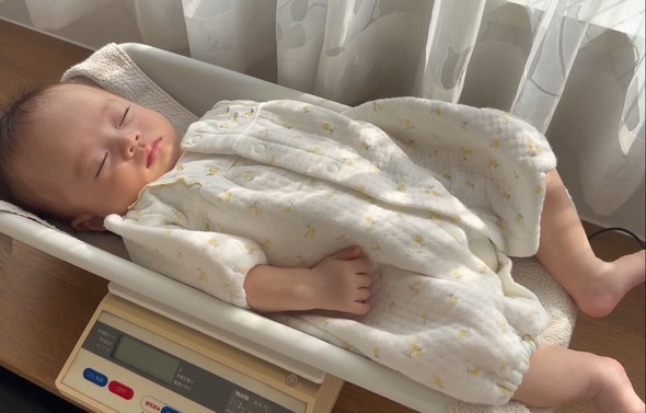 体重計の上で眠る赤ちゃん