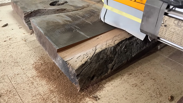 黒い板から木目が少しだけ見えてきたところ