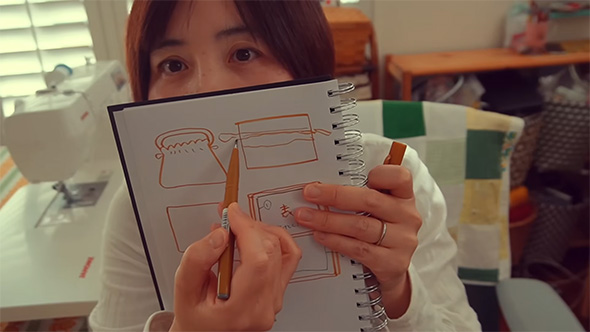 修正したイメージ図を見せる女性