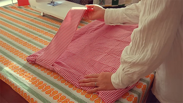 縫っているバッグの持ち手を持ち上げる