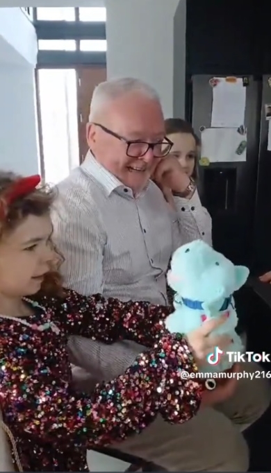 孫たちと一緒にぬいぐるみに微笑む男性