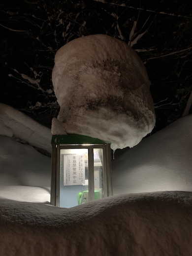 雪に埋もれた公衆電話ボックス