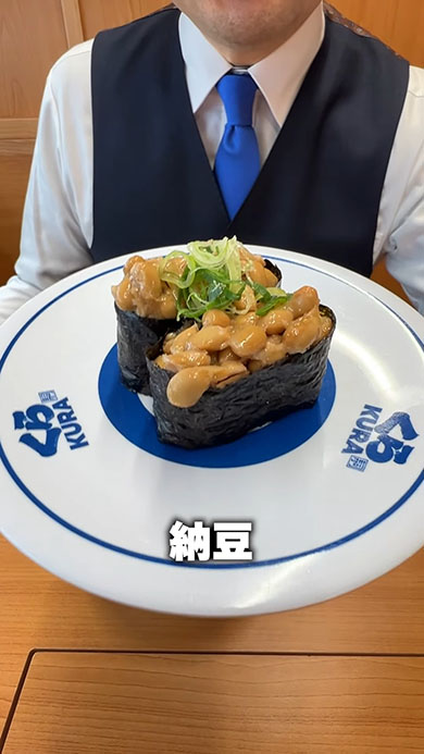 くら寿司メニューの1つ「納豆」を手に取っているところ。テロップに「納豆」と書かれている
