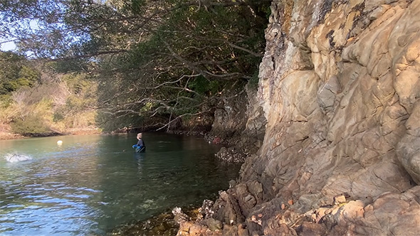 海に入ってカゴを投げる男性
