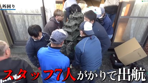 7人がかりで大きな船の置物を搬出