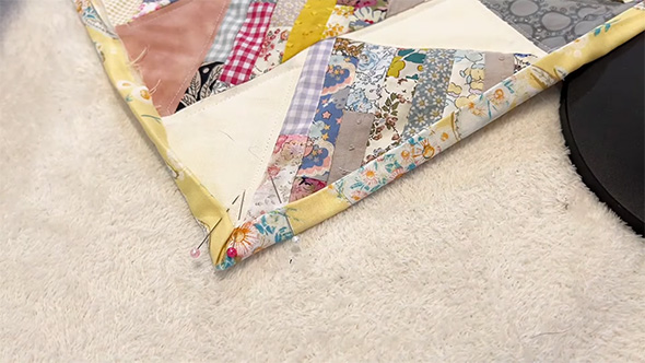 縁取りを折って待ち針で留めているところ