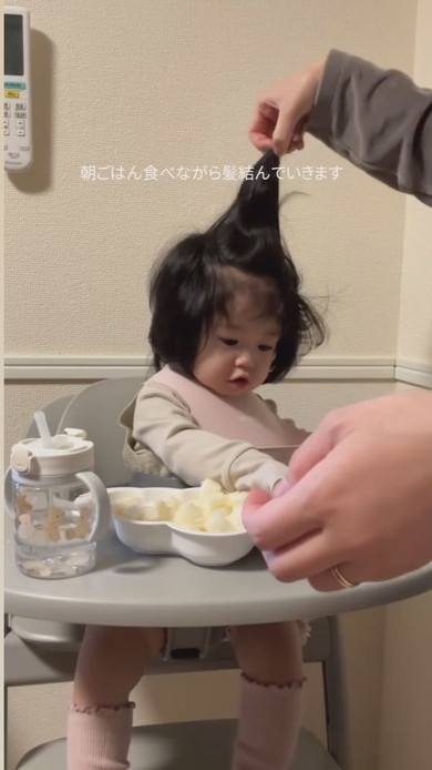 朝食中にヘアセットされる赤ちゃん