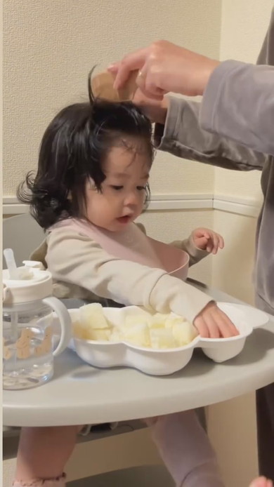 朝食中にヘアセットされる赤ちゃん