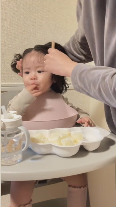 朝食中にヘアセットされる赤ちゃん