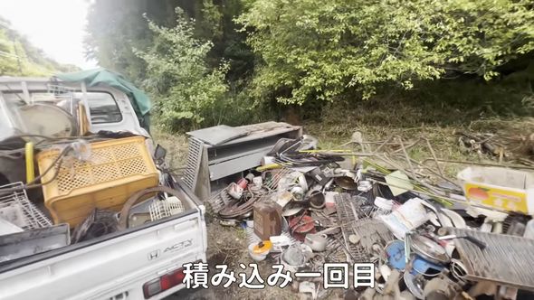屋外にある鉄くずを積んだ軽トラック