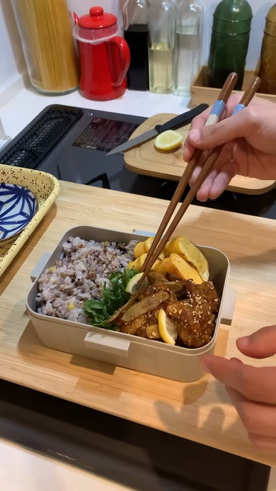 具材をお弁当箱に詰める女性