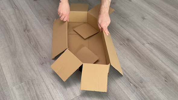 切り込みを入れた段ボールを曲げているところ