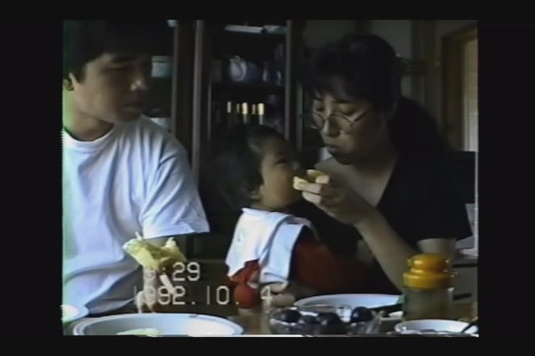 1歳の女の子を両親で挟んだ食事の光景