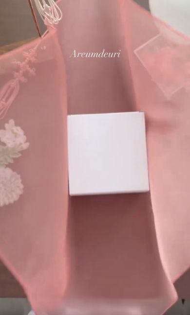 薄いピンクの布で包む