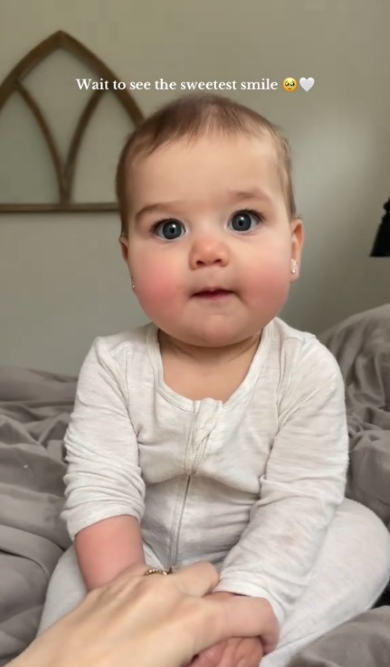 手で押さえられて座る赤ちゃん