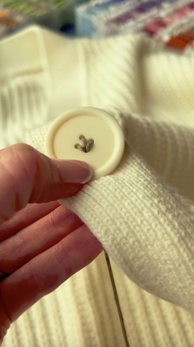 茶色い糸をボタンの穴に通しているところ