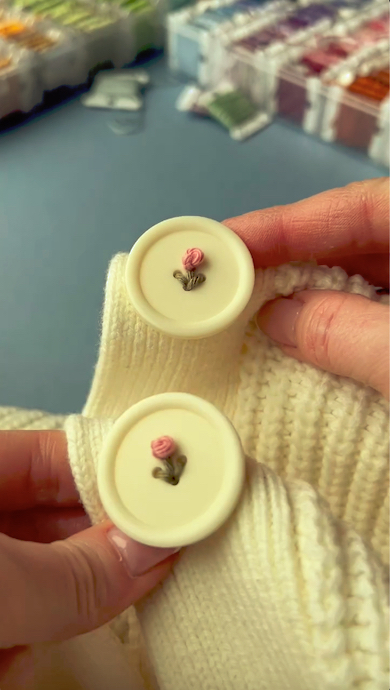 お花の刺しゅうが完成したボタンが2つ並んでいる