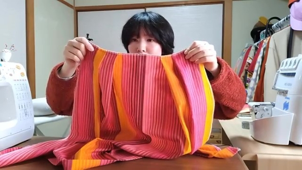 スカートの生地を持つ女性