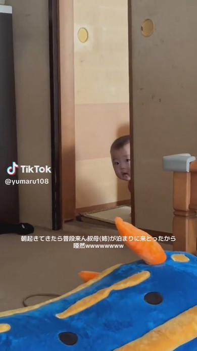 隣室からそっとのぞいている赤ちゃん