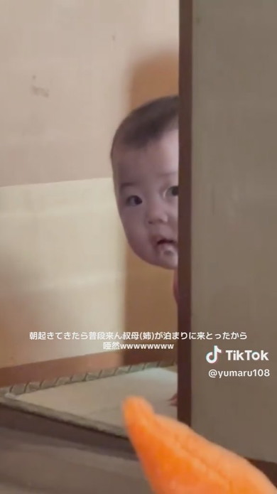 隣室からそっとのぞいている赤ちゃん
