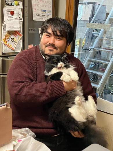 笑顔で猫ちゃんを抱っこしている男性