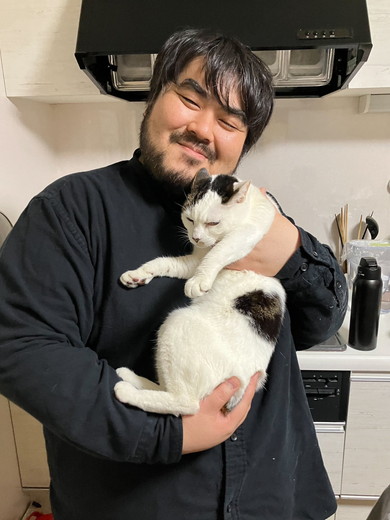 笑顔で猫ちゃんを抱っこしている男性