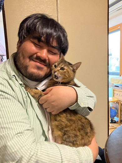 笑顔で猫ちゃんを抱っこしている男性