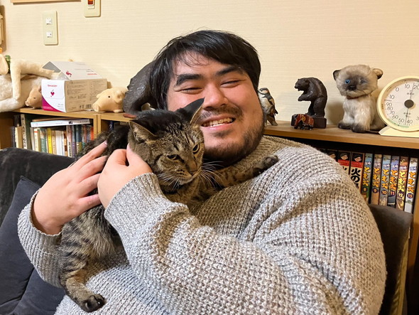 笑顔で猫ちゃんを抱っこしている男性