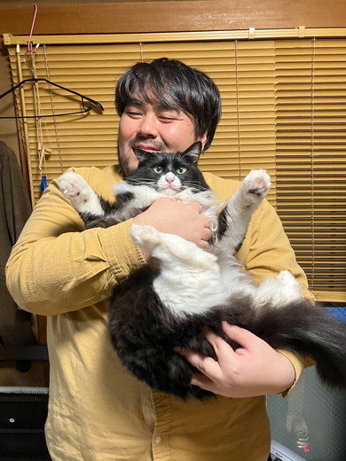 笑顔で猫ちゃんを抱っこしている男性