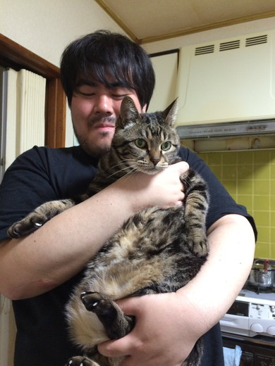 笑顔で猫ちゃんを抱っこしている男性