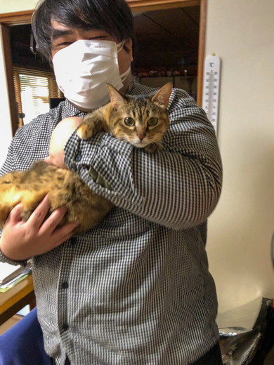 笑顔で猫ちゃんを抱っこしている男性