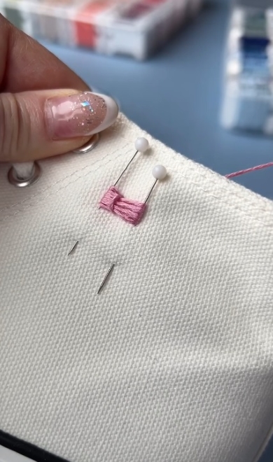 糸を真ん中で引っぱり縫い付ける