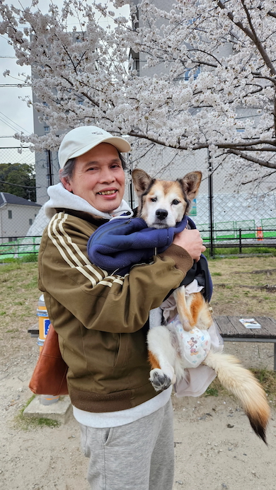 桜を背景にふうさんを抱っこするおじいちゃん