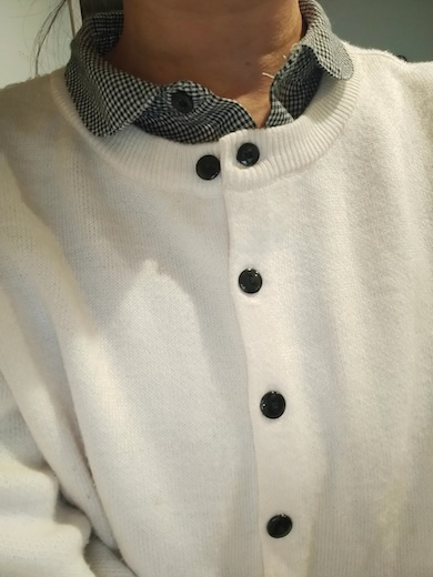 インナーに着ているシャツのボタンをカーディガンにかけてしまっているところ