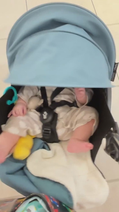 ベビーカーのほろを降ろす赤ちゃん