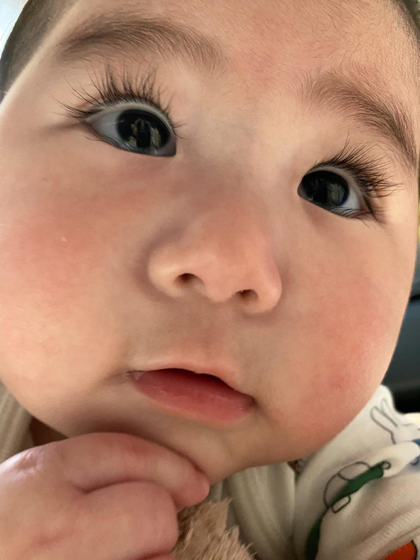 カメラ目線のふさふさまつ毛の赤ちゃん