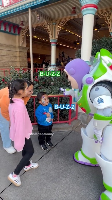 「B-U-Z-Z」を指文字で示すバズと男の子