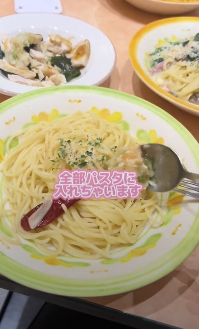 蒸し鶏の香味ソースをペペロンチーノに混ぜているところ。「全部パスタに入れちゃいます」というテロップが表示されている
