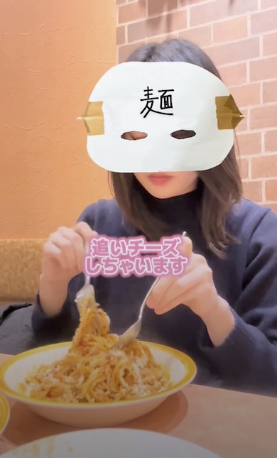 「追いチーズしちゃいます」というテロップが表示されている。背景にはミートソースパスタを混ぜる女性が写っている
