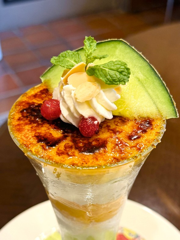  「メロン＆ココナッツのブリュレパフェ」のキャラメリゼにフォーカスした写真 ／ ロイヤルホスト Fresh Melon Dessert 2025